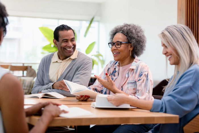 a group of seniors sitting around a table discussing a book